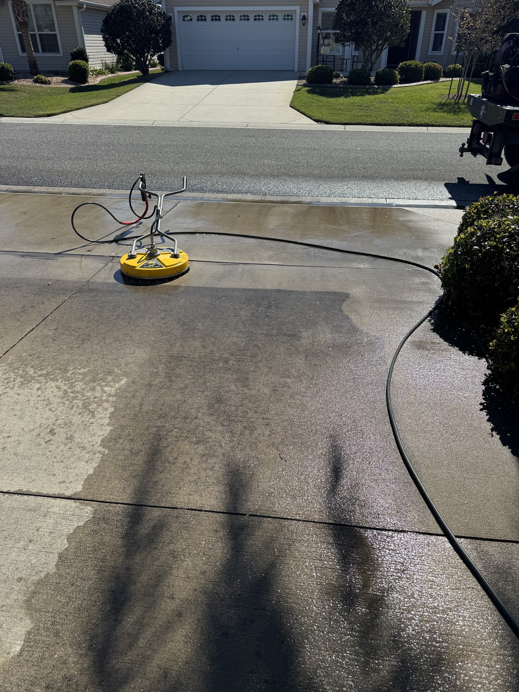 Compton Services pressure washing a driveway in The Villages, Florida — truck and equipment on the job